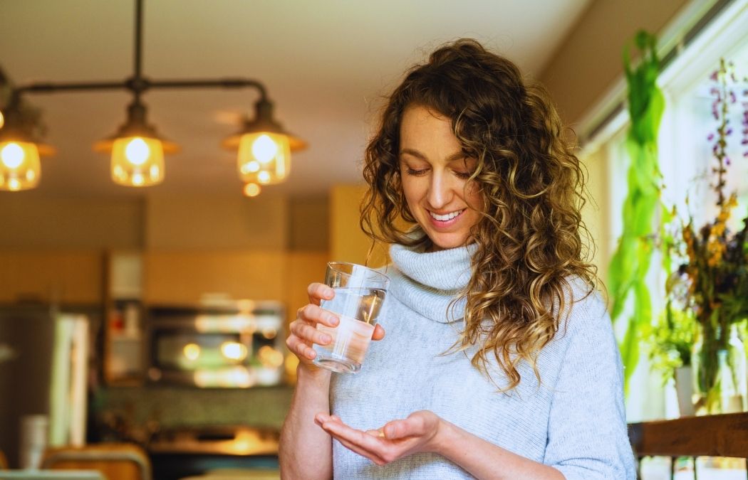 Woman taking her daily supplements to boost brain power