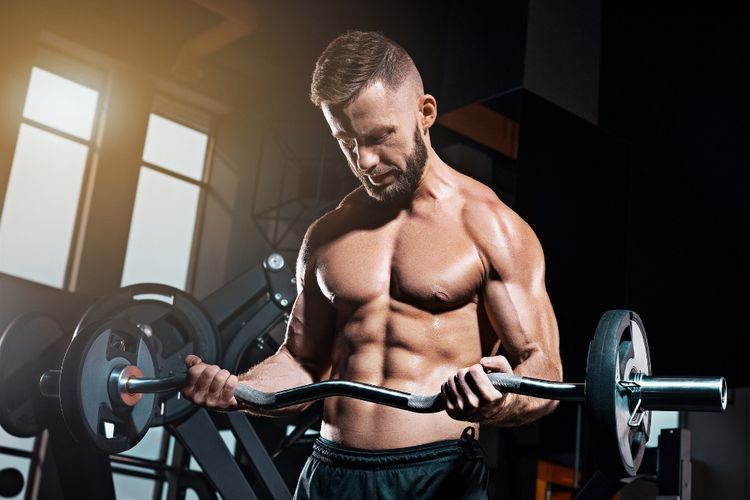 Shirtless muscular man lifting weights