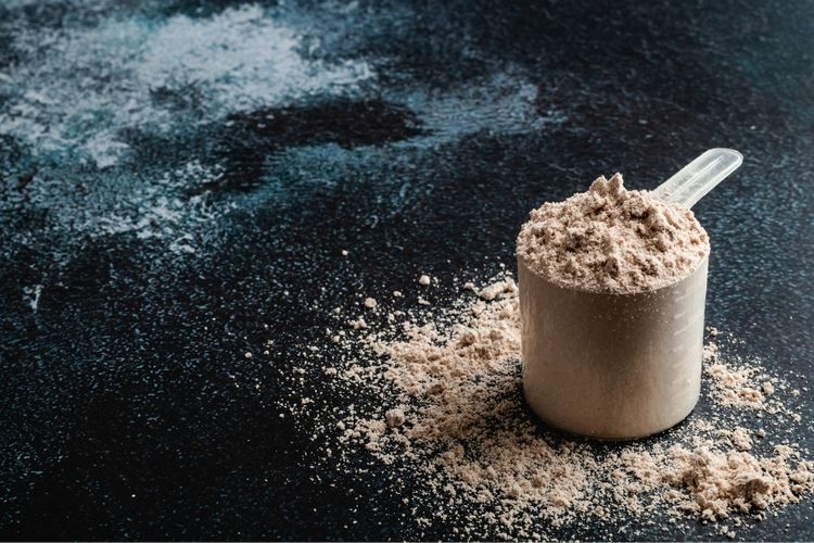 Measuring cup filled with whey protein powder