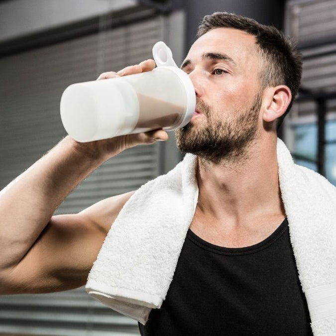 Man at gym drinking shake with Creatine supplements